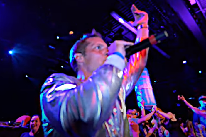 Brad Woodgate in times square with 3 young adults holding cans of Joyburst